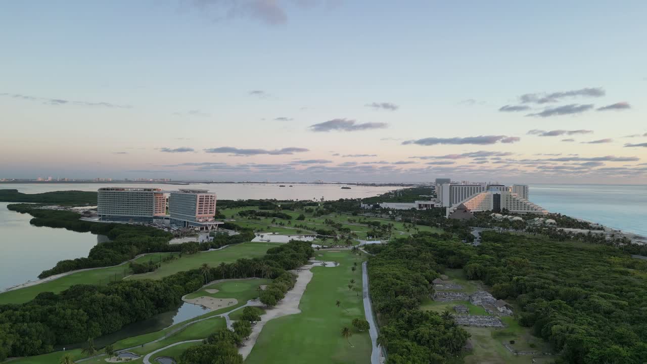 Cancun's lush golf course with resort buildings by the coast, aerial view, playa delfines