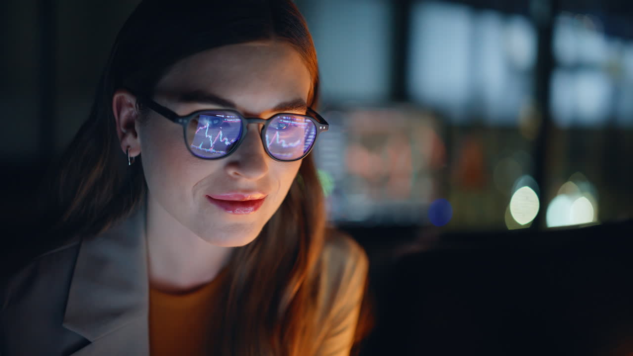 Late evening analyst examining currency fluctuations on notebook device closeup