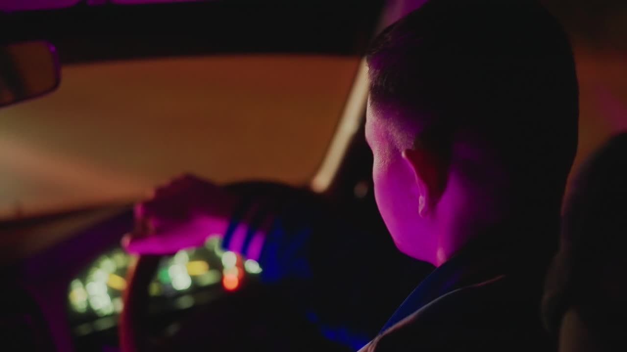Vista trasera de un conductor con luces de neón, conduciendo por avenidas vacías con luces en el salpicadero y un bokeh suave, ambiente de mensajería nocturna, ritmo tranquilo y ambiente reflexivo capturados en ámbar cálido y púrpura