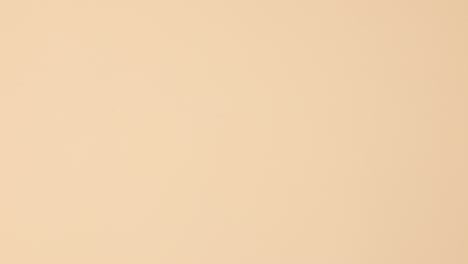 las botellas de esmalte de uñas vibrantes aparecen en la parte superior del fondo beige.