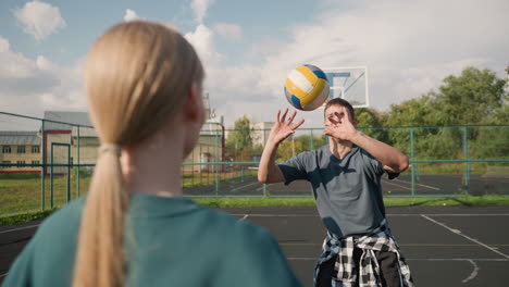 close-up of volleyball training session with youngsters playing together, coach with plaid shirt around waist in open court, building background, teamwork, and practice atmosphere