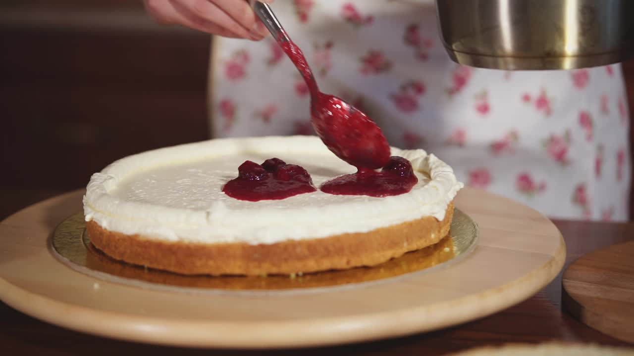 Making a beautiful layered cake with whipped cream and jam