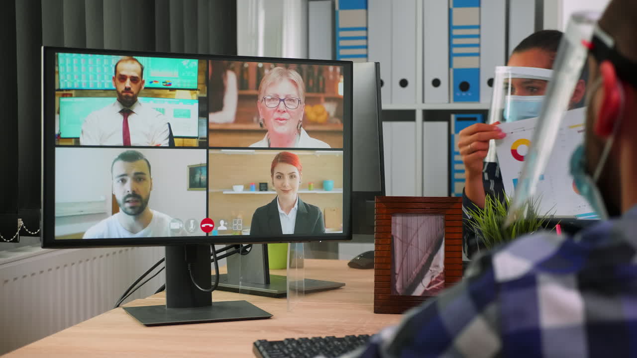 마스크를 착용한 장애인 사업가가 동료들과 온라인에서 대화하고 있습니다.