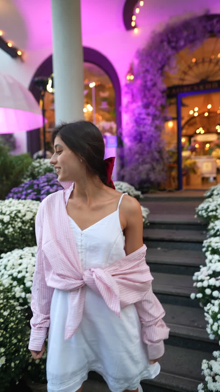 Mulher com Vestido Rosa e Branco Perto de uma Floricultura