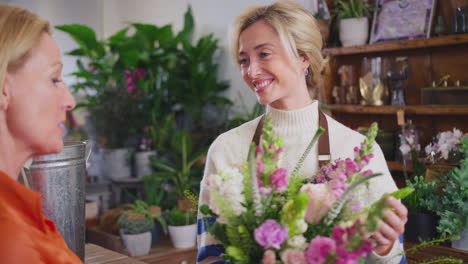 female customer in florists shop buying bouquet of flowers