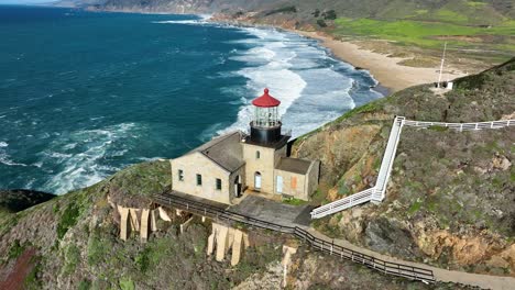 Toma-Aérea-Del-Faro-De-Point-Sur-En-El-Acantilado-Del-Mar-Contra-Las-Olas-Azules-Del-Océano,-Big-Sur-California