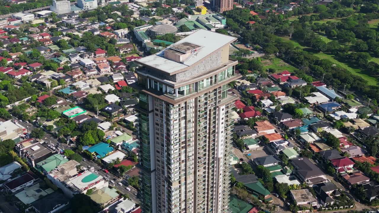 Aerial orbit of luxury residential tower, Viridian, surrounded by homes at Greenhills, San Juan City, Philippines.