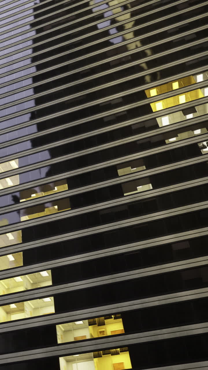 View of building with dark windows and warm lights from below at night