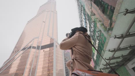 photographer taking a picture of a skyscraper in a city