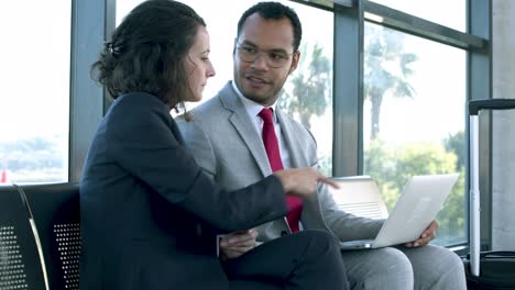 Smiling-business-people-using-laptop