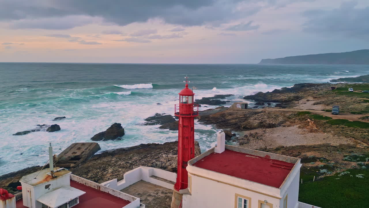 Scenic beacon standing rocky coast washed by stormy ocean water aerial view.
