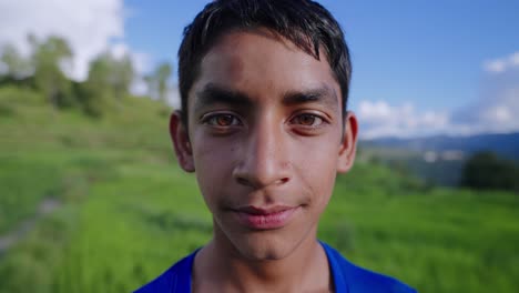 close-up shot of anxious indian kid standing alone in lush rice fields, looking around uncertainly, 4k video