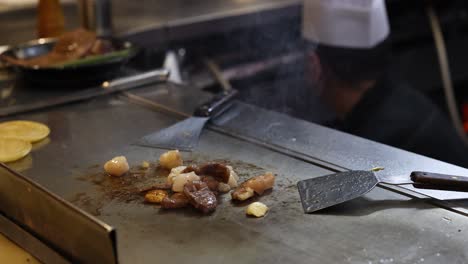 chef preparing food on a hot teppanyaki grill