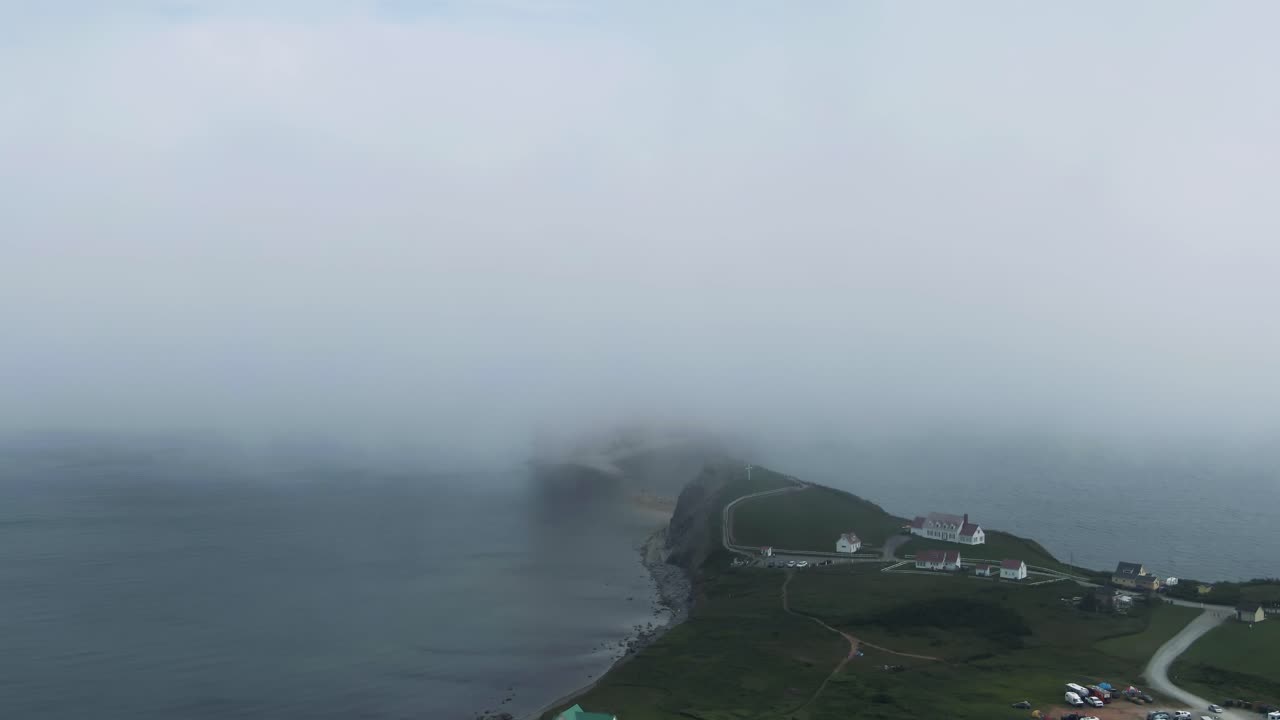 캐나다 퀘벡 주 세인트 로렌스 만에 있는 구름 뒤에 있는 페르세 바위의 멋진 전망 - 공중 드론