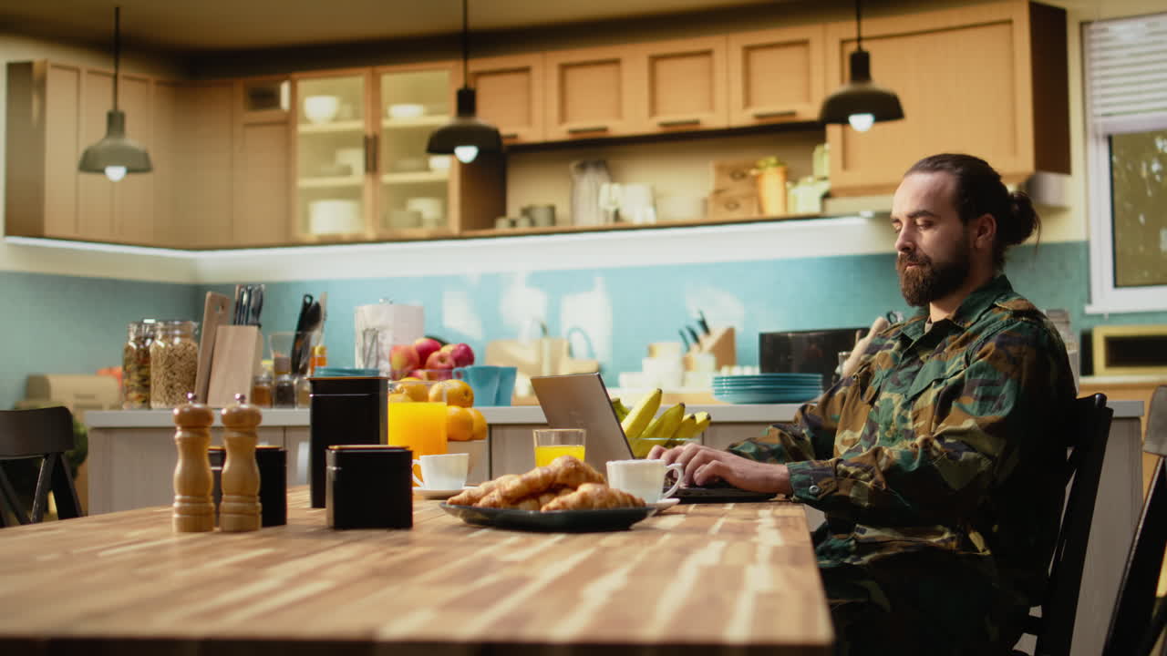 Militar de uniforme camuflado aproveitando uma manhã tranquila com café em casa