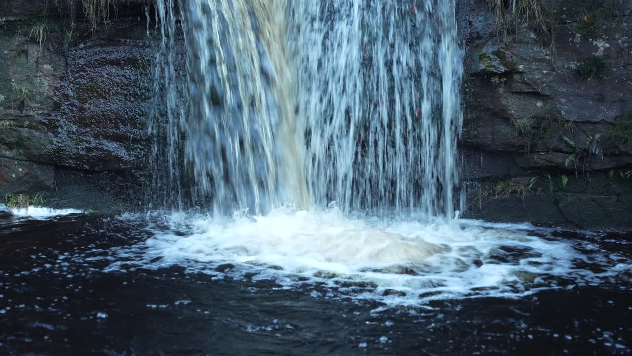 작은 폭포가 자연 수영장으로 들어가는 클로즈업, 물이 거품이 나고 거품이 아지는 모습