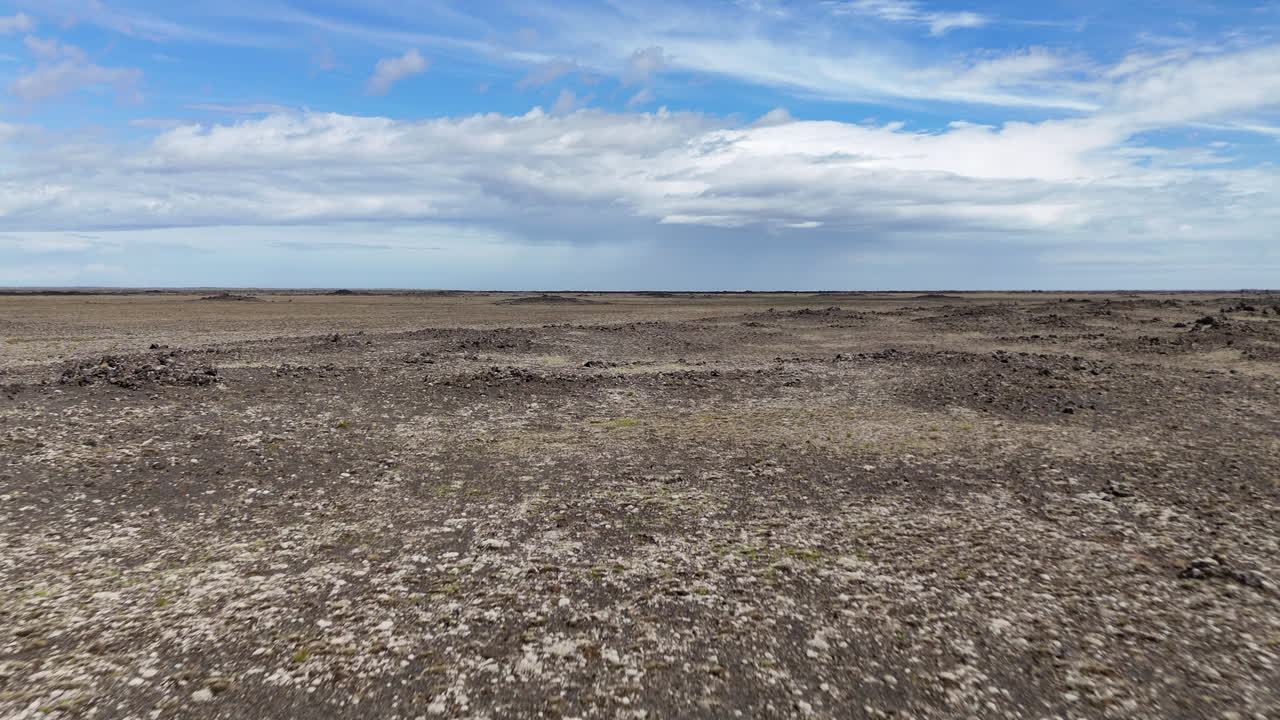 Vast Icelandic moss-covered plains leading to Mýrdalsjökull glacier under heavy dramatic storm clouds and distant mountains