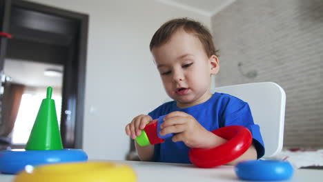 baby boy learning colors and shapes playing with toys. toddler studying through the game. low angle view.