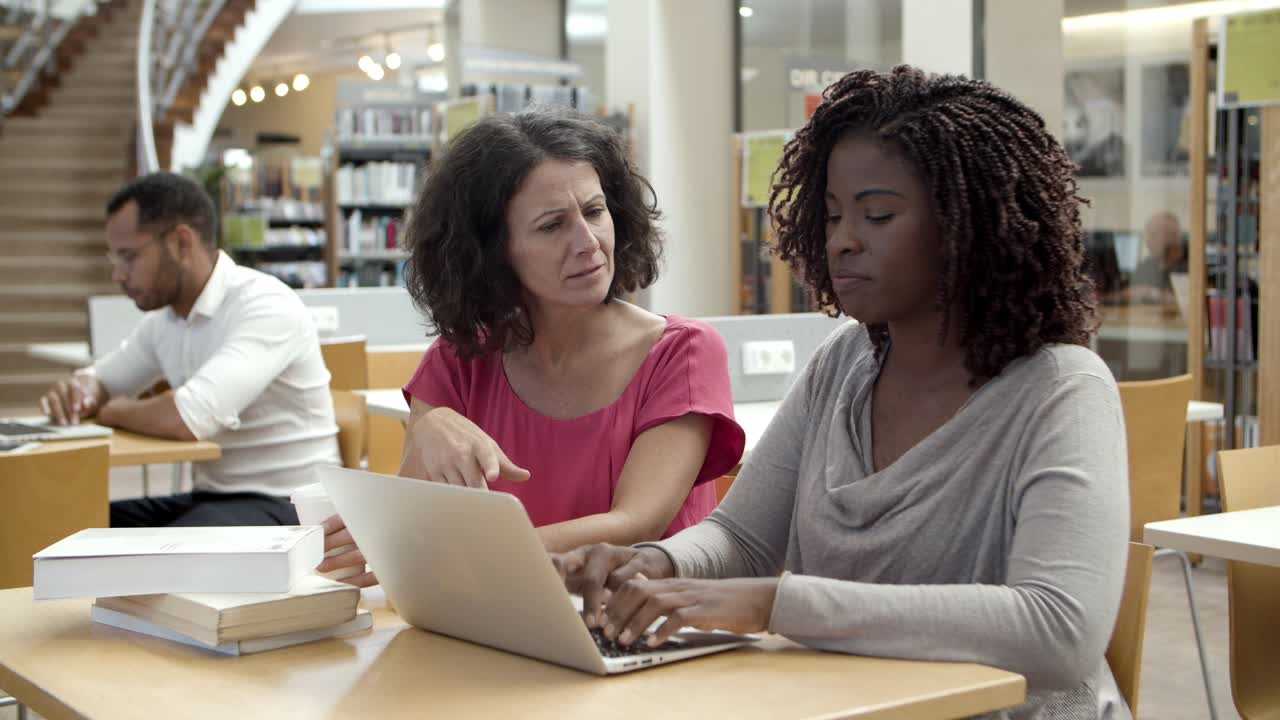 estudiantes pensativos trabajando en un proyecto en la biblioteca