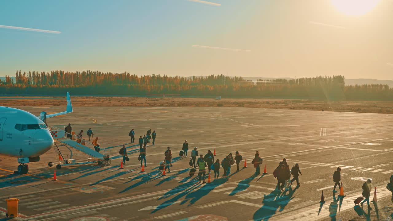 Passengers Boarding Airplane on Tarmac During Golden Hour