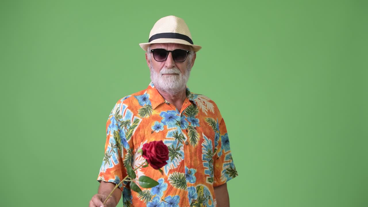 hombre turista barbudo y guapo listo para las vacaciones contra un fondo verde