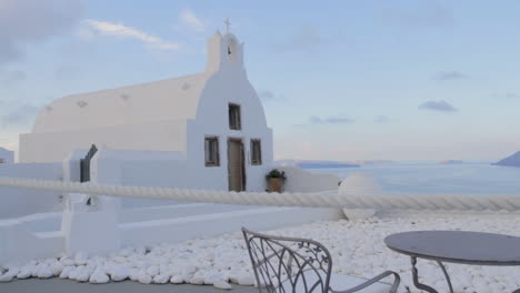 tracking in shot of a small greek chapel overlooking the caldera with an amazing sea view