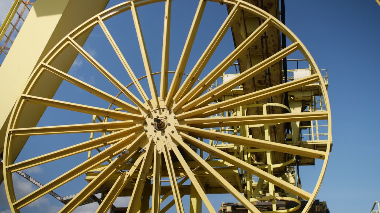 Industrial yellow container cranes in Park Spoor Oost, Antwerp, set against a clear blue sky