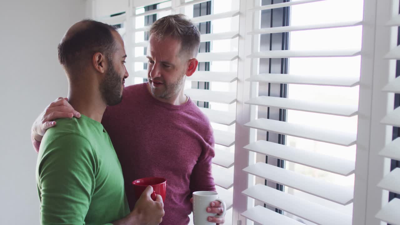 casal de homens gays multiétnicos a beber café e a conversar