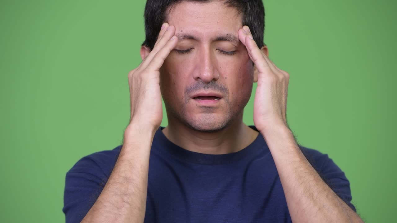 Stressed Hispanic man having headache