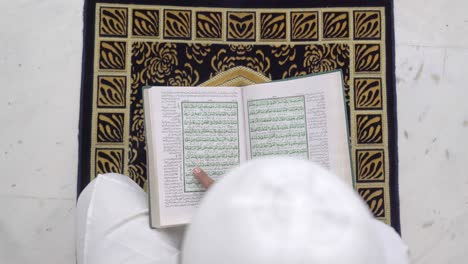 indian muslim man reading quran holy book