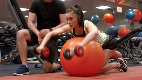 Woman-lifting-dumbbells-with-her-trainer