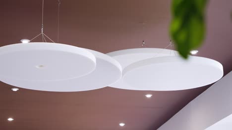 slow rotating shot of circular ceiling panels hanging in a hotel entrance