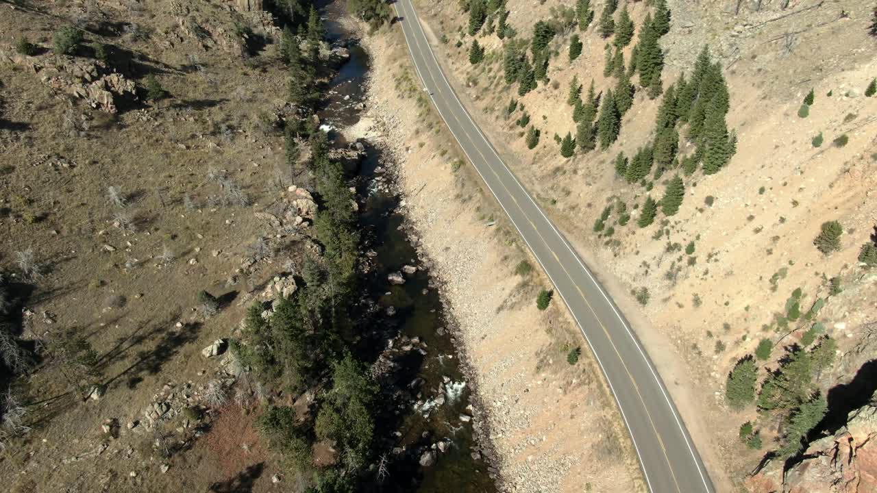 avance aéreo sobre la carretera en el cañón junto al río en colorado