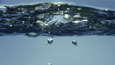 shiny Air Bubbles Rising up on Water Surface and Bursting Shiny Air Bubbles Rising up on Calm Surface of Water Bursting and Forming Splash Freshness of Clear Blue Liquid Poured into Container Transparent Blue Aqua with Light Glare Close up Liquid through the Glass Boiling Water Bubbling