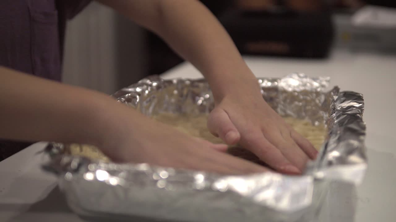 어린 소녀가 백만장자 쇼트브레드 쿠키를 만들기 위해 베이킹 트레이에 크러스트를 준비합니다-3