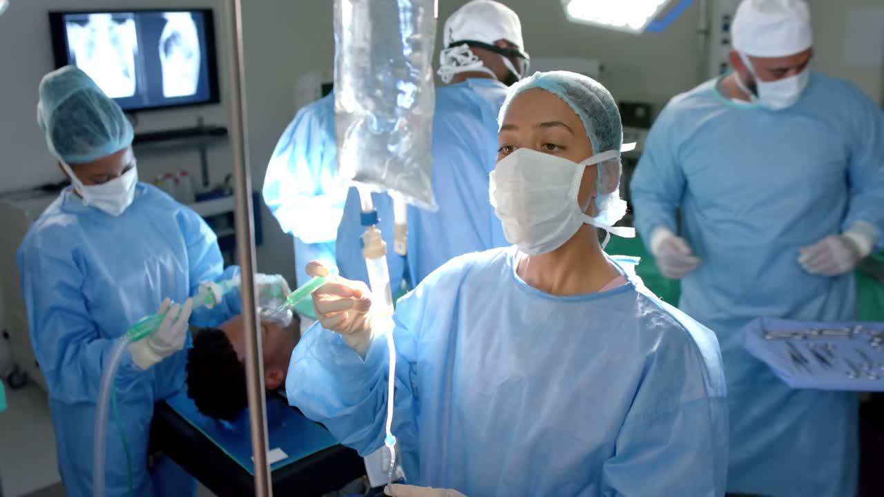 수술복을 입은 다양한 외과의사들이 수술실에서 물방울을 투여하고, 슬로우 모션