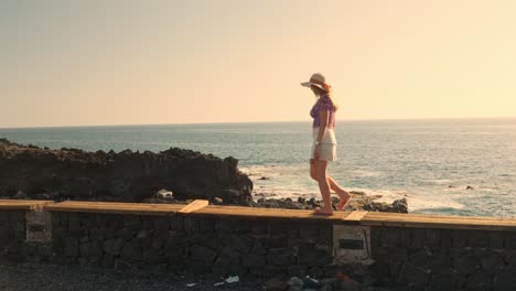 young woman admires sunset sky and walks away in tenerife