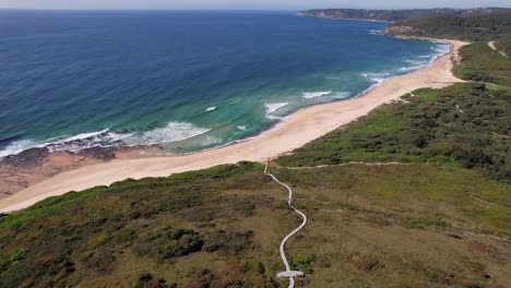 dudley beach with turquoise ocean in new south wales, australia - aerial pullback
