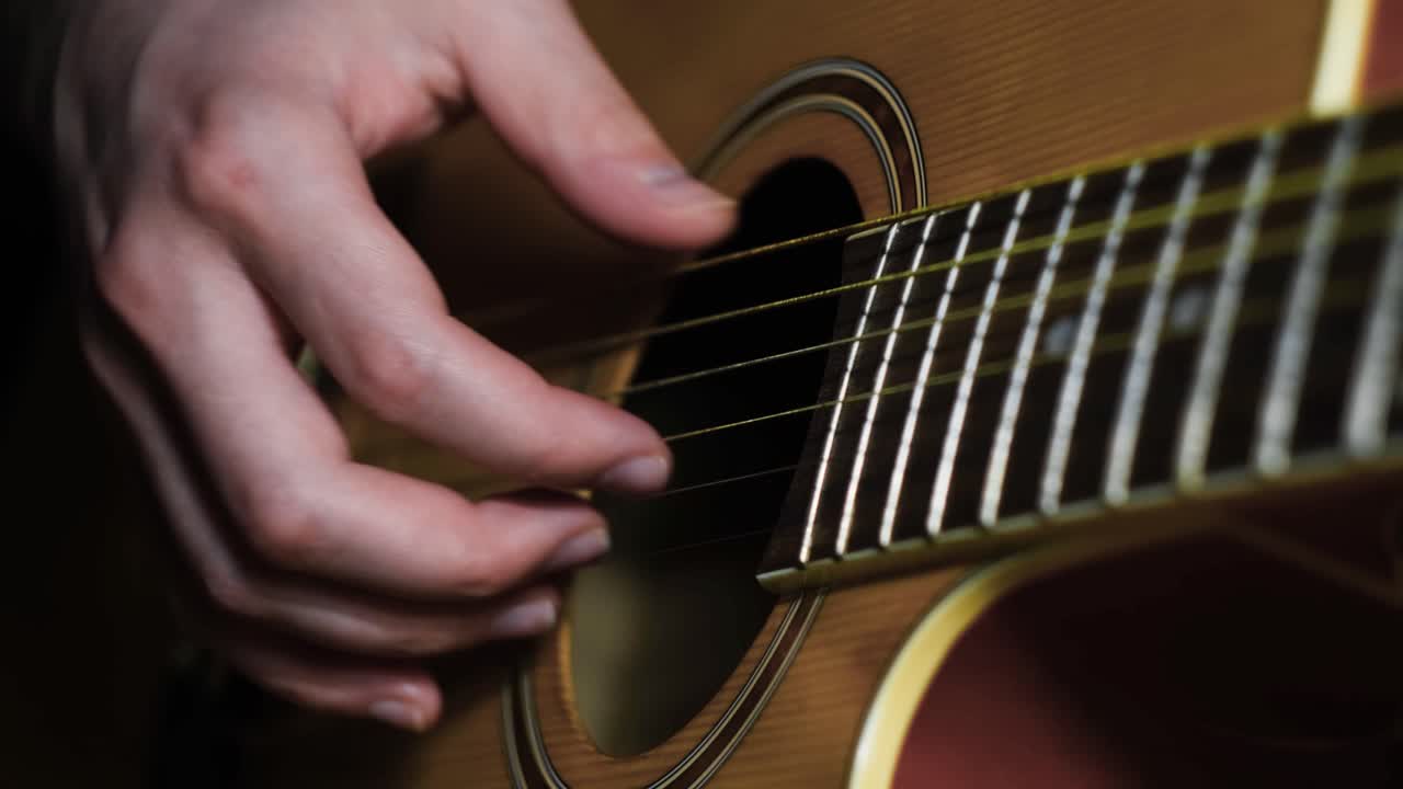 primer plano de manos tocando una guitarra acústica