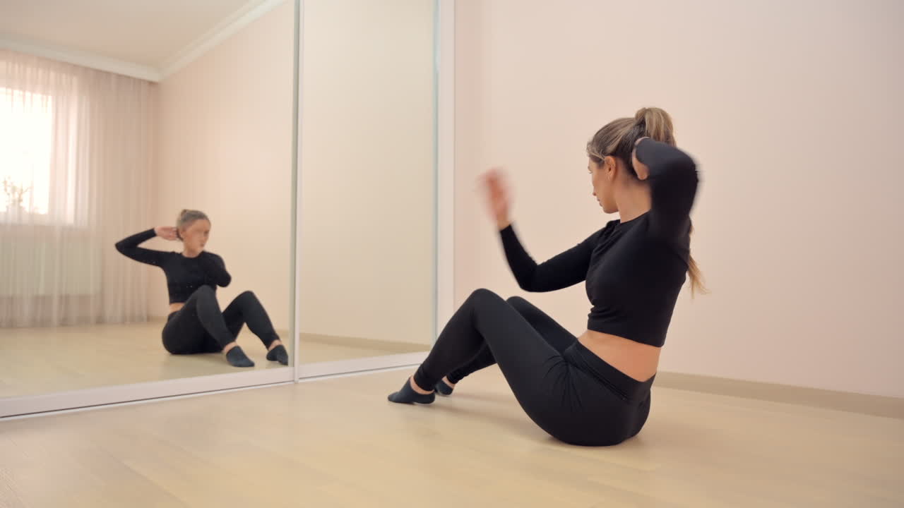 Woman in black activewear training in front of a mirror