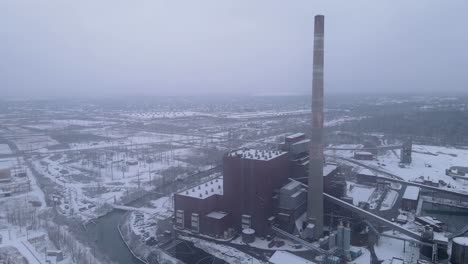 chimneys of abandoned coal power plant in detroit, aerial drone orbit view