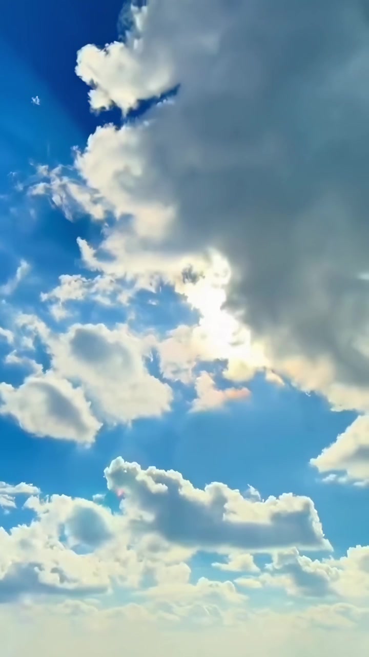 Cielo azzurro sereno con nuvole soffici e sole splendente
