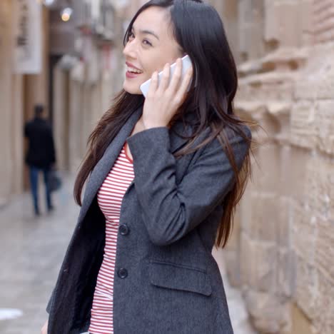 young woman walking through town with her mobile