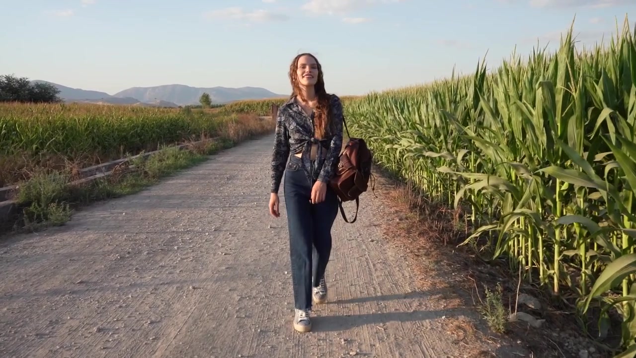 Una donna passeggia tranquillamente lungo un pittoresco sentiero in un suggestivo paesaggio rurale
