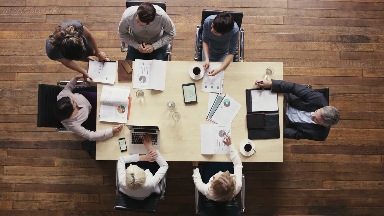 vista superior diversas personas de negocios se reúnen en la mesa de la sala de juntas discutiendo el informe financiero