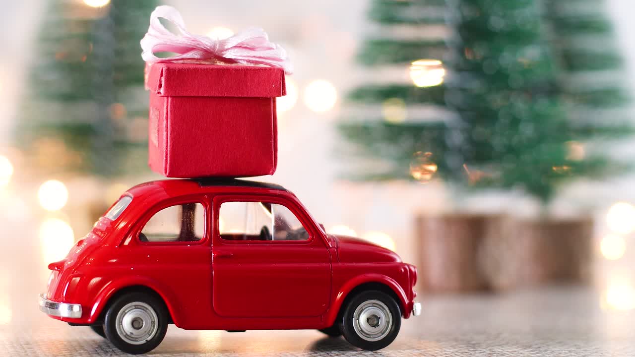 Auto d'epoca rossa con regali di Natale rossi sul tetto