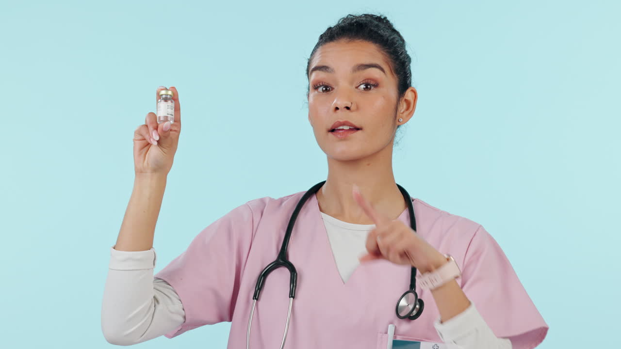 여자가 백신 병을 가리키고 있습니다.