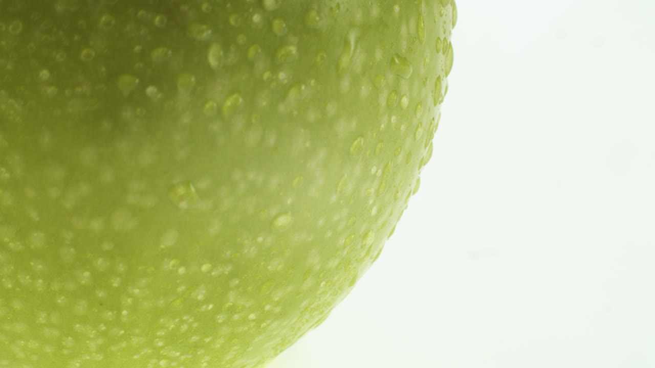 primer plano de una manzana verde con gotas de agua sobre ella