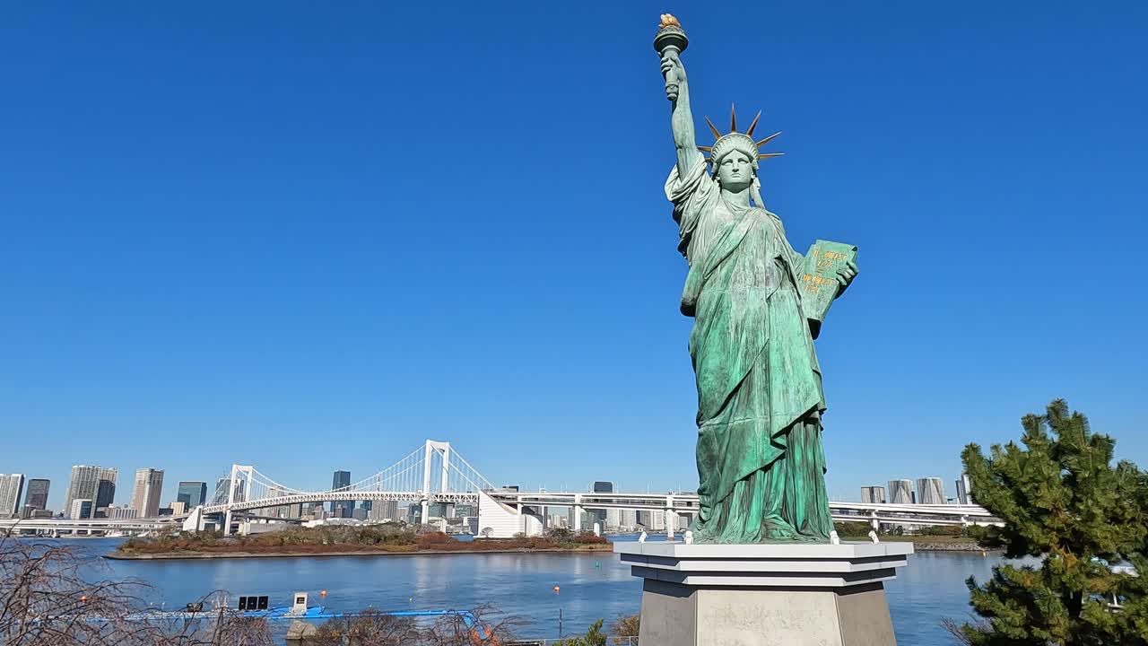 Die Freiheitsstatue und die Regenbogenbrücke als Wahrzeichen in Odaiba, Tokio, Japan