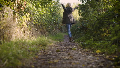 mujer caminando por un sendero en el bosque